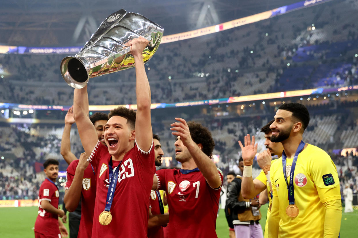 Qatar's Mostafa Meshaal lifts the AFC Asian Cup trophy after beating Jordan in the final in Doha.