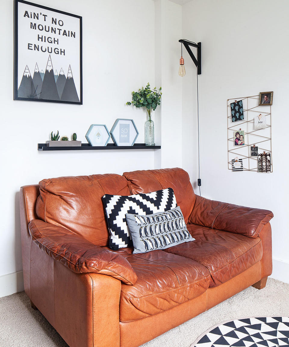 leather sofa small white living room with shelf and wall light