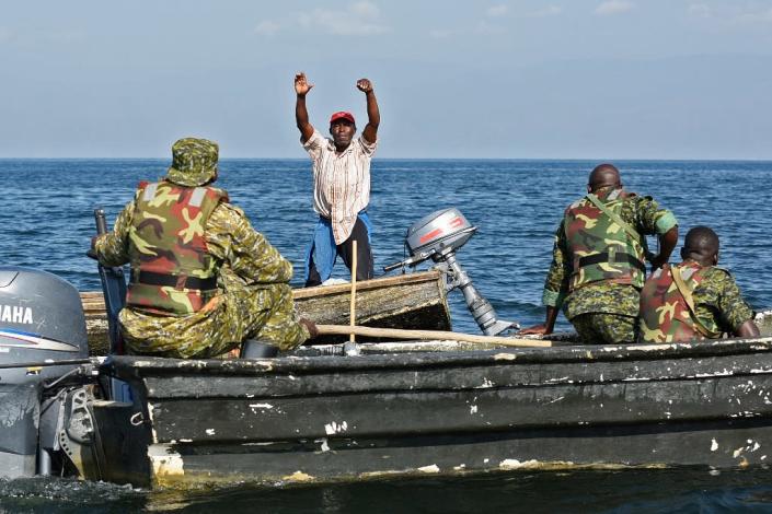 A fisherman from the Democratic Republic of Congo raises his hands to surrender to Uganda forces patrolling Lake Edward, which is shared by the two countries (AFP Photo/ISAAC KASAMANI)