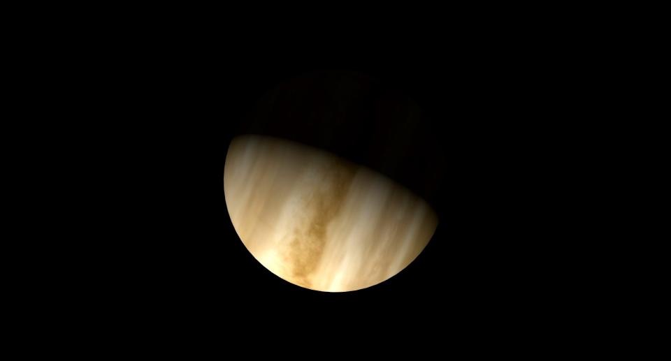 a quarter venus layed on its side in a black sky