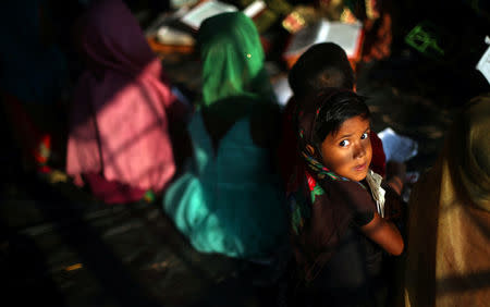 A Rohingya refugee girl listens during a Quran reading lesson in a mosque in Palong Khali refugee camp near Cox's Bazar, Bangladesh, October 24, 2017. REUTERS/Hannah McKay