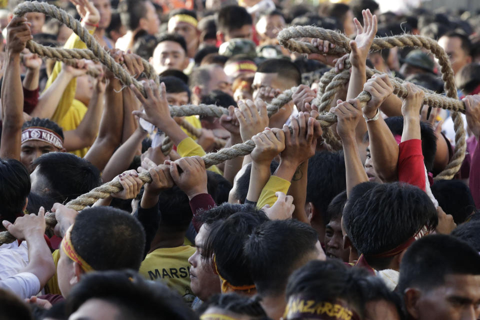 Filipino Roman Catholic devotees jostle to get the rope that pulls the carriage of the Black Nazarene during a raucous procession to celebrate its feast day Thursday, Jan. 9, 2020, in Manila, Philippines. A mammoth crowd of mostly barefoot Filipino Catholics prayed for peace in the increasingly volatile Middle East at the start Thursday of an annual procession of a centuries-old black statue of Jesus Christ in one of Asia's biggest religious events. (AP Photo/Aaron Favila)
