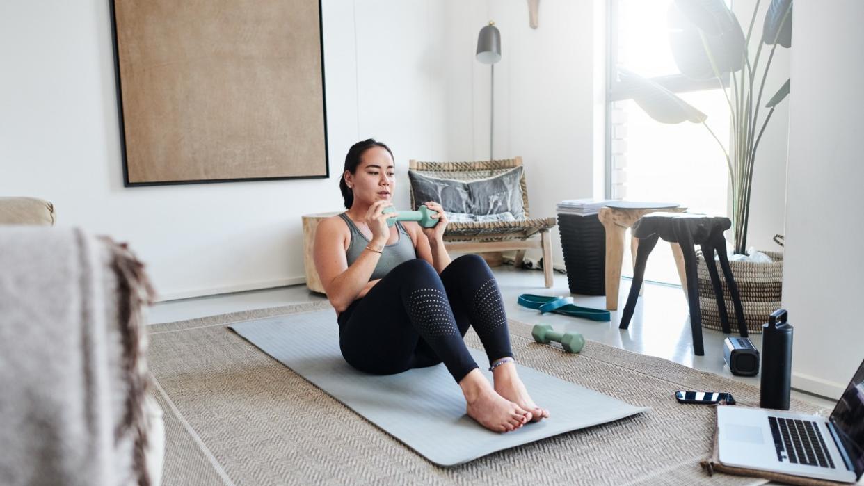  Woman performs weighted sit-up 