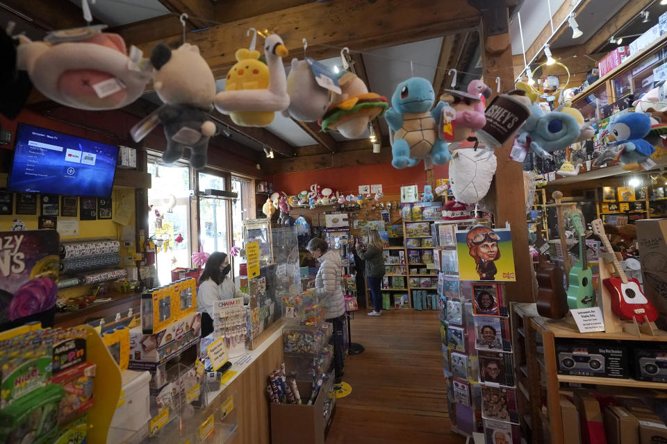 Customers shop at a Five Little Monkeys store in Berkeley, Calif., Monday, Dec. 12, 2022. Small retailers say this year looks much different than the last "normal" pre-pandemic holiday shopping season of 2019. They're facing decades-high inflation forcing them to raise prices and making shoppers rein in the freewheeling spending seen in 2021 when they were flush with pandemic aid and eager to spend. (AP Photo/Jeff Chiu)