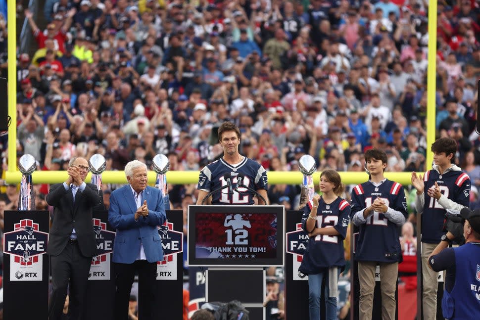 New England Patirots President Jonathan Kraft, New England Patriots owner Robert Kraft clap as former New England Patriots quarterback Tom Brady speaks while Brady's children, Vivian, Benjamin, and Jack, clap during a ceremony honoring Brady at halftime of New England's game against the Philadelphia Eagles at Gillette Stadium on September 10, 2023 in Foxborough, Massachusetts.