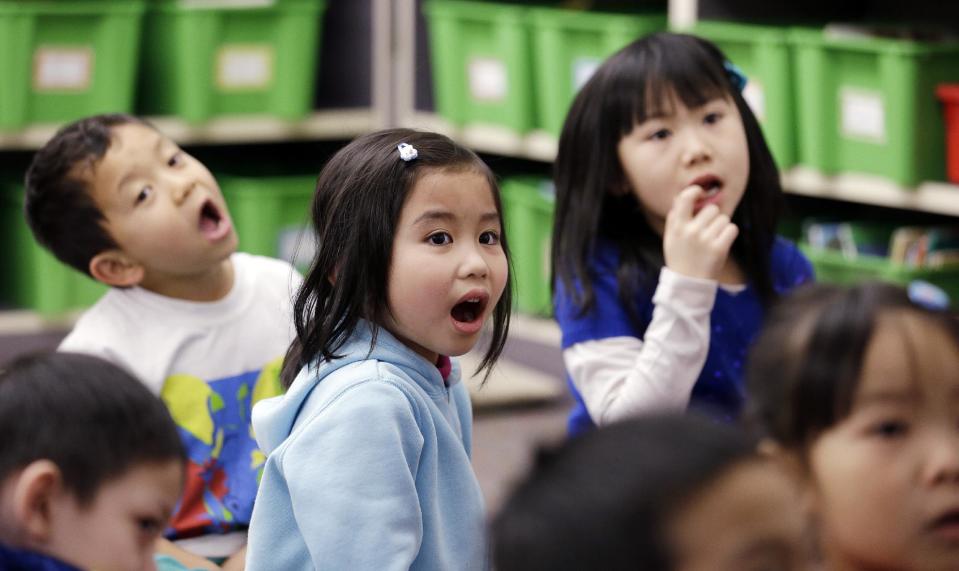 ** HOLD FOR AMY TAXIN STORY ** In this photo taken Friday, Feb. 14, 2014, kindergarten students in a dual immersion language class repeat the names of fish anatomy back to their teacher in Vietnamese at White Center Heights Elementary School in Seattle. In a handful of schools across the country, kindergartners aren’t being taught just in English, but also in Vietnamese. The move to add Vietnamese to the growing list of languages featured in dual immersion education classes comes as the American born children of Vietnamese immigrants are striving to preserve their family’s heritage for the next generation. (AP Photo/Elaine Thompson)