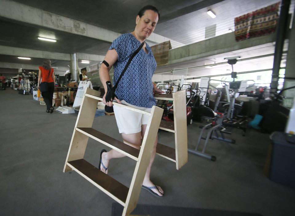 Katie Wahlman walks out with furniture after her purchase at the Rummage RAMPage, a week-long community garage sale designed to keep reusable items out of the waste stream, at Ames Intermodal Facility in Campustown on Monday, July 31, 2023, Ames, Iowa.