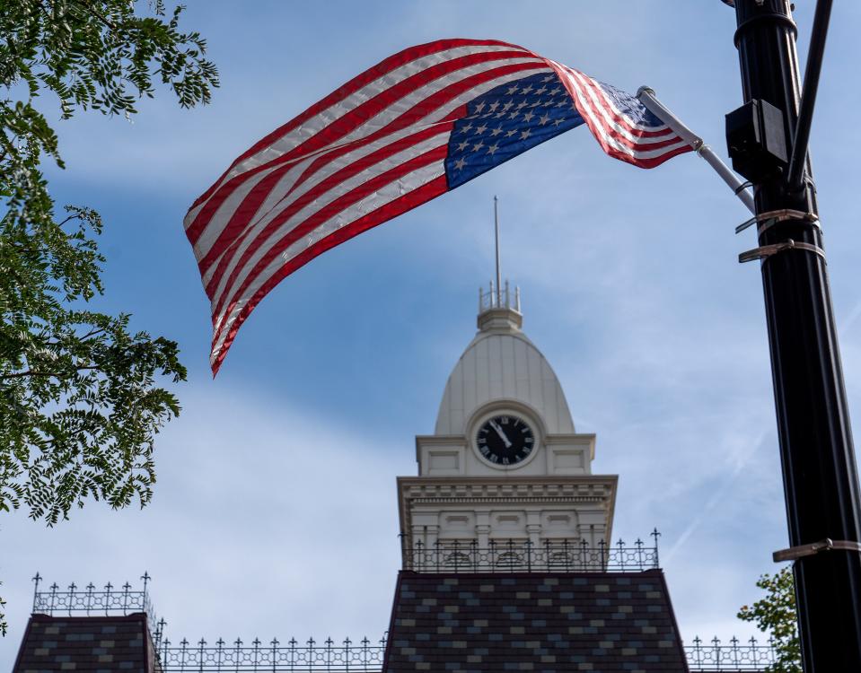 A flag waves in the breeze near the Randolph County Courthouse in Winchester, where many local residents said they support arming specially trained teachers to respond to school-shooter incidents. Surveys show support for the controversial tactic is strongest among Republican voters in rural areas.