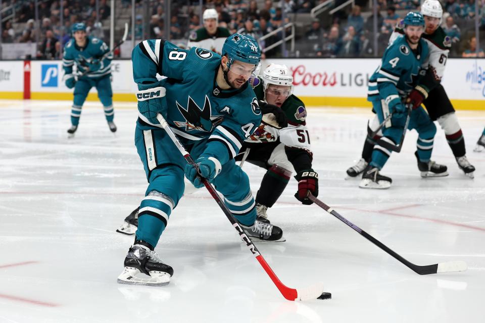 Tomas Hertl #48 of the San Jose Sharks keeps the puck from Troy Stecher #51 of the Arizona Coyotes in the second period at SAP Center on Dec. 21, 2023 in San Jose, California.