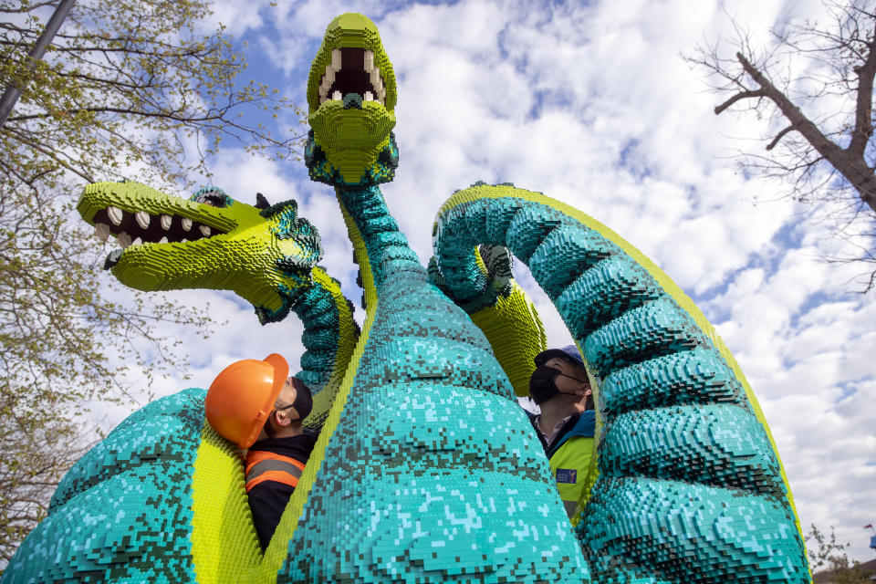 <p>Theo Papadopoulos (left) and Matt Phillips checks one of the newly installed LEGO models in the new LEGO Mythica land at LEGOLAND Windsor Resort. Picture date: Tuesday April 27, 2021.</p>
