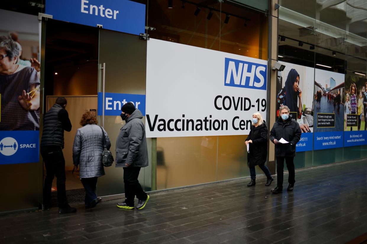 People queue to enter an NHS Covid-19 vaccination centre in Westfield Stratford City shopping centre in east London on February 15, 2021 as Britain's largest ever vaccination programme continues. - Prime Minister Boris Johnson called Britain hitting a target of inoculating 15 million of the most vulnerable people with a first coronavirus jab 