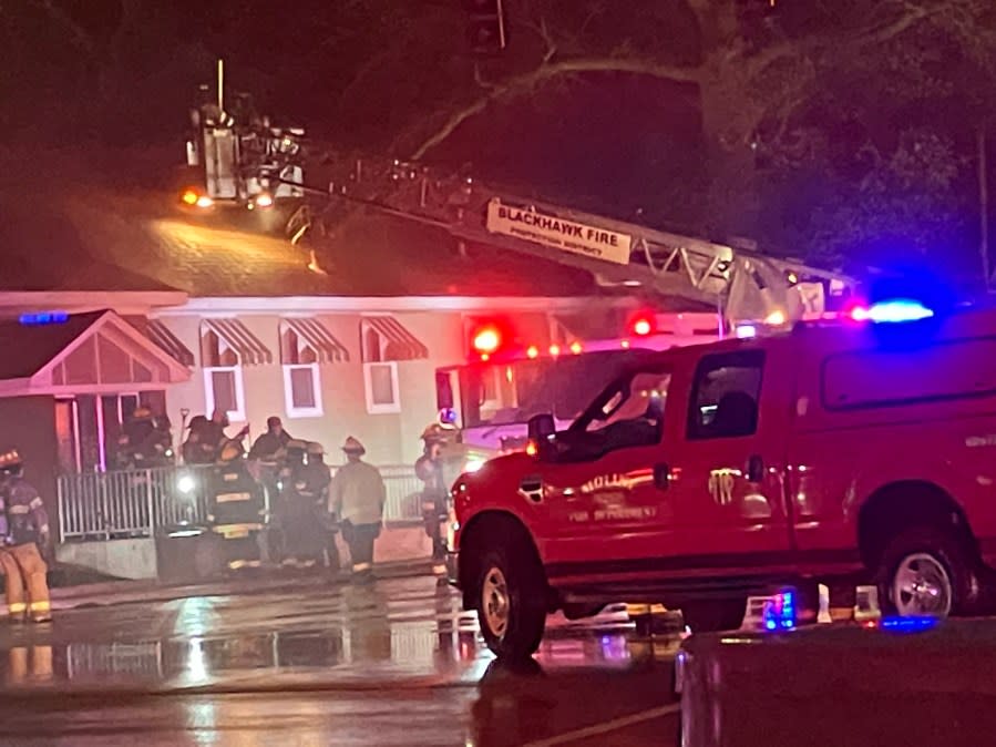 While rain pours down, firefighters work to control a fire Tuesday night in a dentists’ office in Coal Valley. Crews used a ladder truck to reach the roof to vent the building with a chainsaw. (Mike Colón)