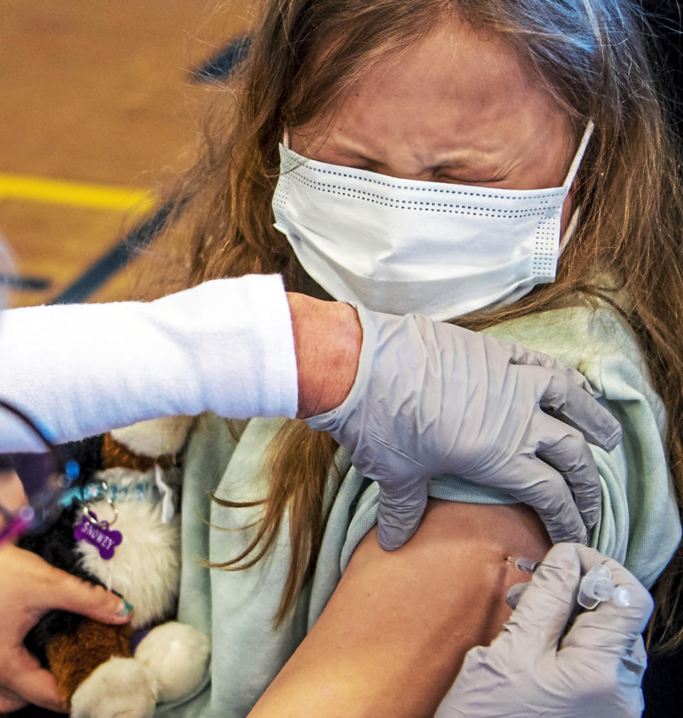 Linda Zeigler, of nurse with St. Clair Health, administers the Pfizer COVID-19 vaccine to Anita Murphy, 12, of Brookline, at a clinic organized by St. Clair Health and the Carnegie Boys and Girls Club to vaccinate youth ages 12 and older, Saturday, May 15, 2021, in Carnegie, Pa. (Alexandra Wimley/Pittsburgh Post-Gazette via AP)