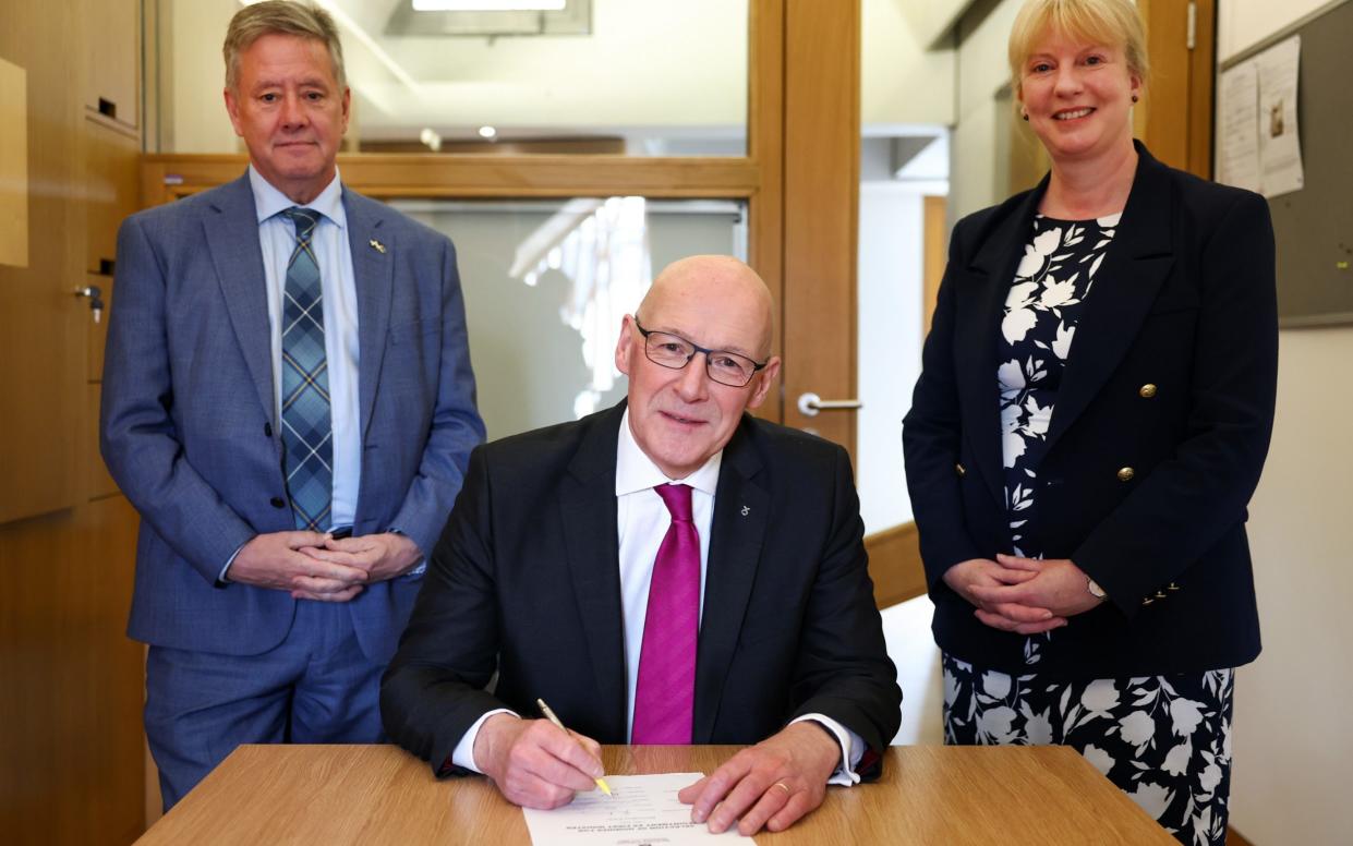 New Scottish National Party (SNP) leader John Swinney signs his letter of nomination to become First Minister, with his proposers Shona Robison (right) and Keith Brown, at the Scottish Parliament in Edinburgh