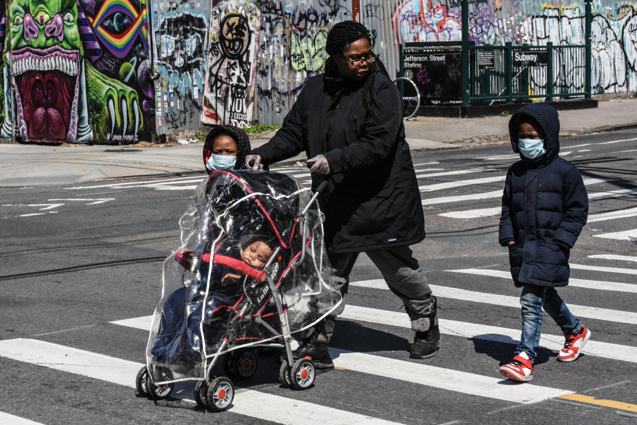 A new study from the CDC has found a higher prevalence of COVID-19 cases among young boys than girls. Here, a child wears a protective masks while standing on a corner in Brooklyn. (Photo: Stephanie Keith/Getty Images)