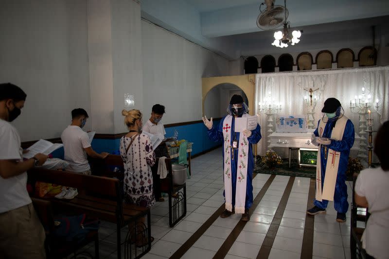 The Wider Image: Hazmat suits and holy water: two priests bring faith to Philippines lockdown