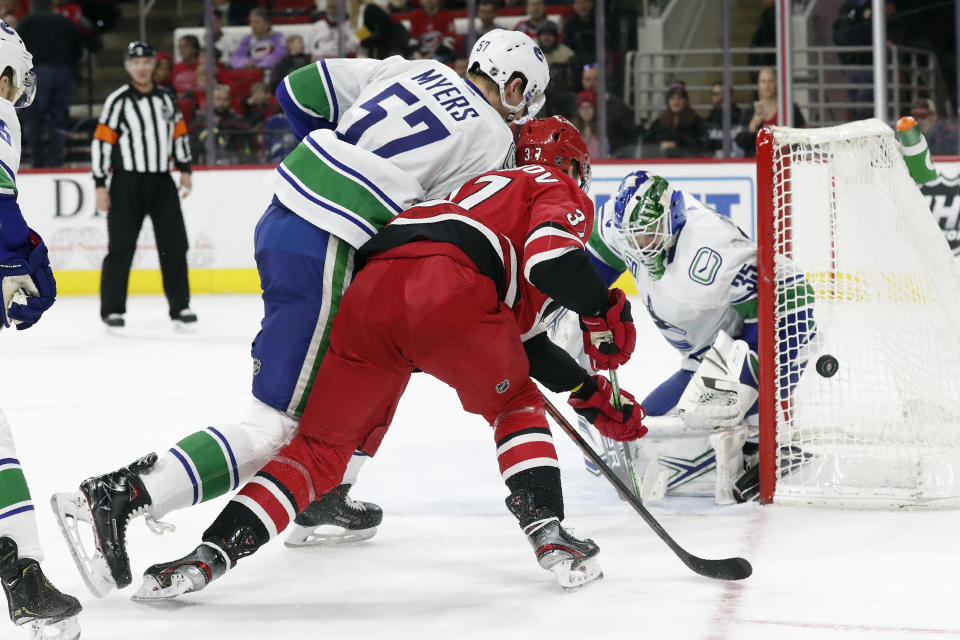 Carolina Hurricanes right wing Andrei Svechnikov (37), of Russia, tries to score while Vancouver Canucks defenseman Tyler Myers (57) and goaltender Thatcher Demko (35) defend during the second period of an NHL hockey game in Raleigh, N.C., Sunday, Feb. 2, 2020. (AP Photo/Gerry Broome)