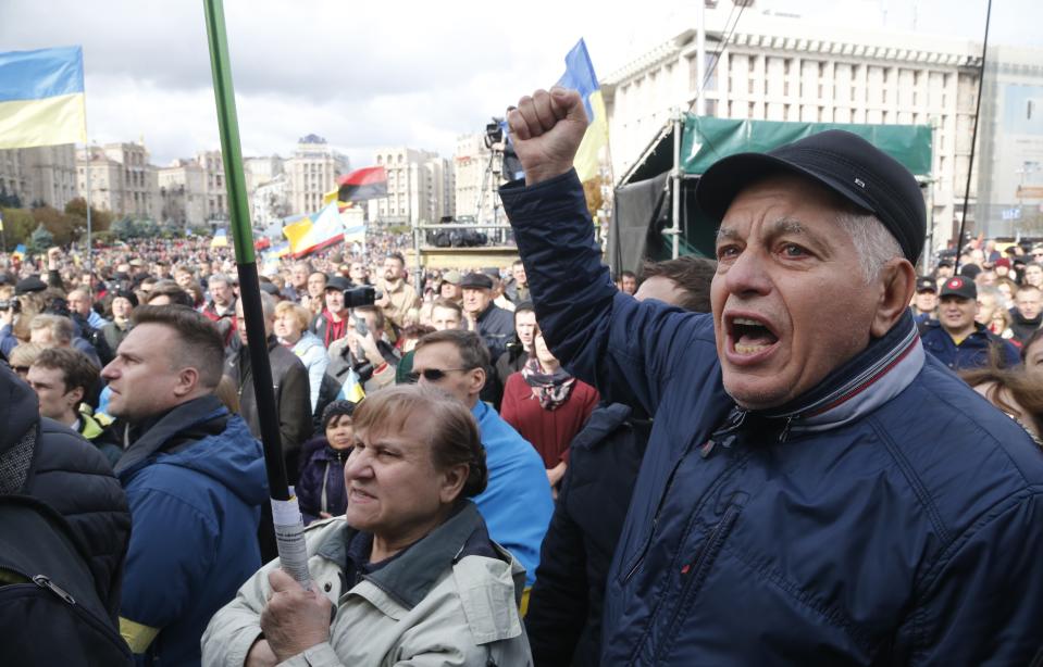 Protesters react as they listen to a speaker during a rally in Independence Square in Kyiv, Ukraine, Sunday, Oct. 6, 2019. Thousands are rallying in the Ukrainian capital against the president's plan to hold a local election in the country's rebel-held east, a move seen by some as a concession to Russia. (AP Photo/Efrem Lukatsky)