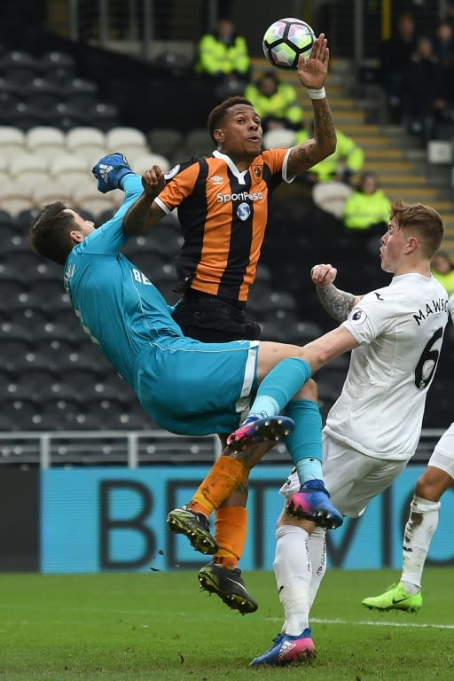 Hull City's Abel Hernandez (C) vies with Swansea City's Lukasz Fabianski and Alfie Mawson (R) during their English Premier League football match on March 11, 2017