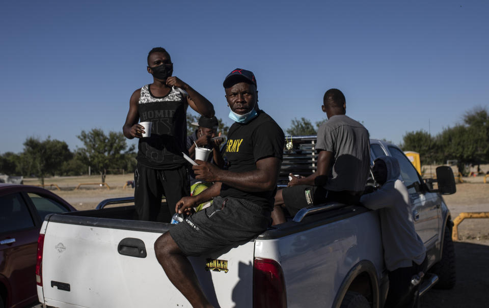 Migrants board the back of a truck at an encampment after agreeing to be transferred to a shelter, in Ciudad Acuna, Mexico, Friday, Sept. 24, 2021, across the Rio Grande from Del Rio, Texas. No migrants remained Friday at the Texas border encampment in Del Rio where almost 15,000 people — most of them Haitians — had converged just days earlier seeking asylum, local and federal officials said. (AP Photo/Felix Marquez)