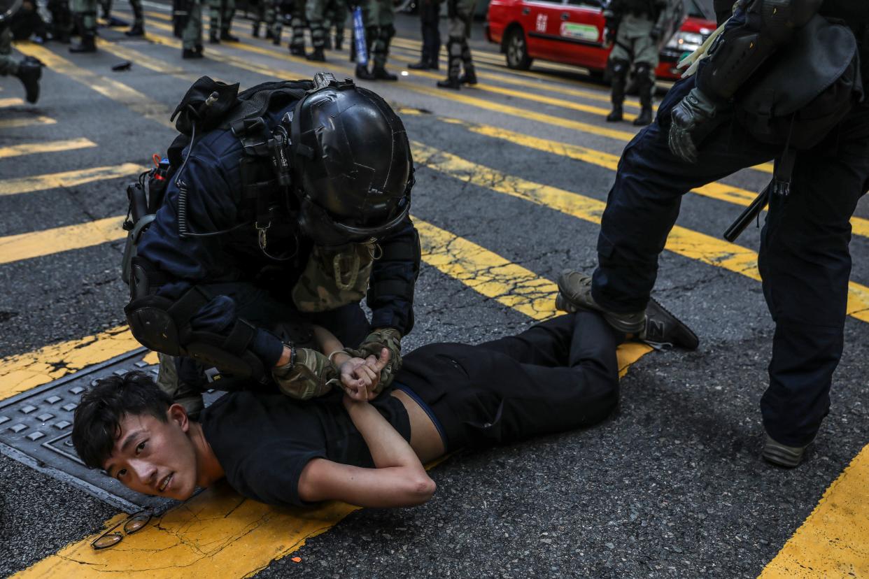 Police detain a demonstrator during a flash mob protest in the Central district in Hong Kong on November 13, 2019. - Pro-democracy protesters stepped up on November 13 a "blossom everywhere" campaign of road blocks and vandalism across Hong Kong that has crippled the international financial hub this week and ignited some of the worst violence in five months of unrest. (Photo by DALE DE LA REY / AFP) (Photo by DALE DE LA REY/AFP via Getty Images)