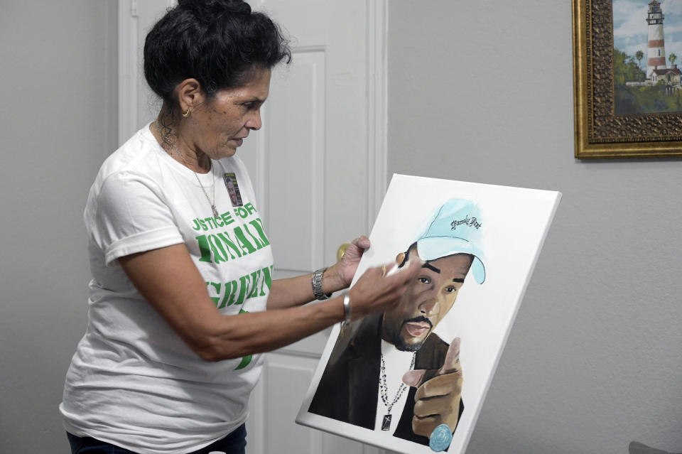 FILE - Mona Hardin recounts the events surrounding the death of her son, Ronald Greene, as she holds a painting of him in Orlando, Fla., on Saturday, Dec. 4, 2021. Hardin remains skeptical about the prospects of the state case against the five white officers charged in his death, after her attorneys told her the “wild card” Hugo Holland had been hired. “All I hear is that he doesn’t like losing,” she said. “But who is he winning for? Is he doing this for the blue?” (AP Photo/Phelan M. Ebenhack, File)