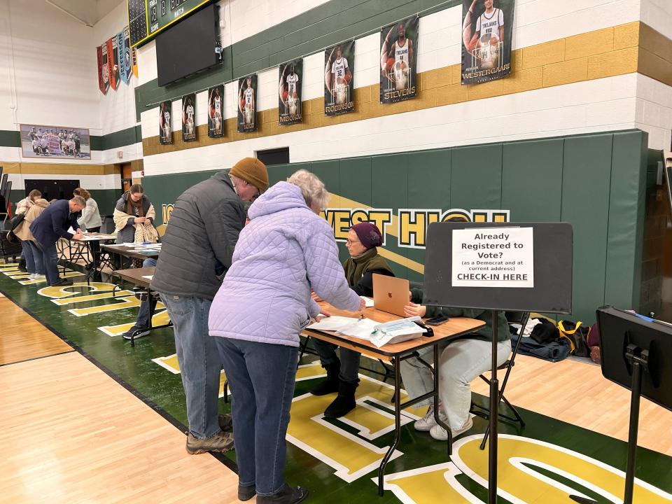 Volunteers help Democratic caucusgoers check in before the start of the caucus Monday, Jan. 15 at Iowa City West High.