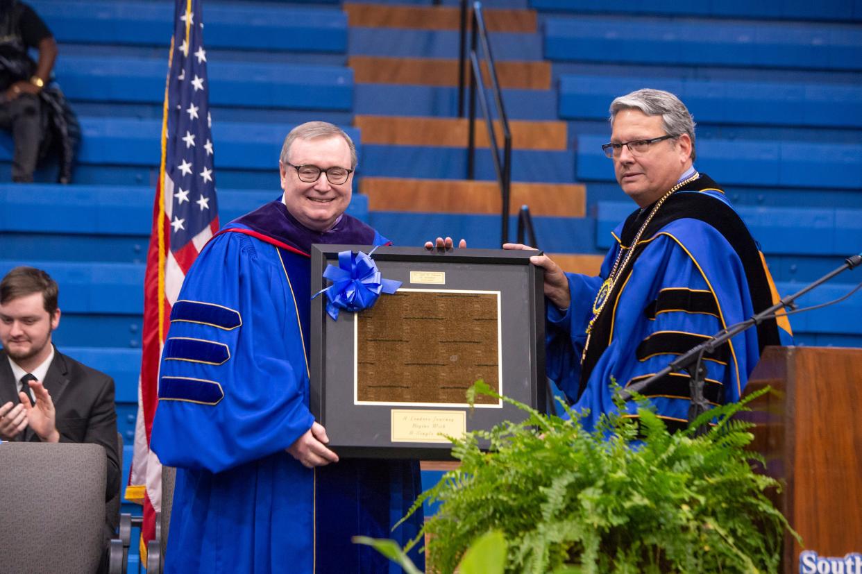 Chancellor Emeritus and former Southeastern president Glen D. Johnson receives a gift from Southeastern president Thomas Newsom. Johnson was the speaker at both ceremonies.