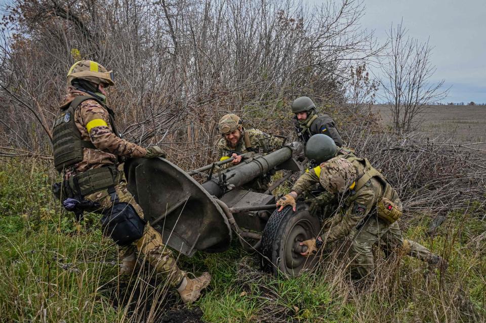 Members of Ukrainian National Guard push a mortar launcher at a position along the front line in Kharkiv region on October 25, 2022, amid the Russian invasion of Ukraine. (Photo by SERGEY BOBOK / AFP) (Photo by SERGEY BOBOK/AFP via Getty Images) ORIG FILE ID: AFP_32M643L.jpg