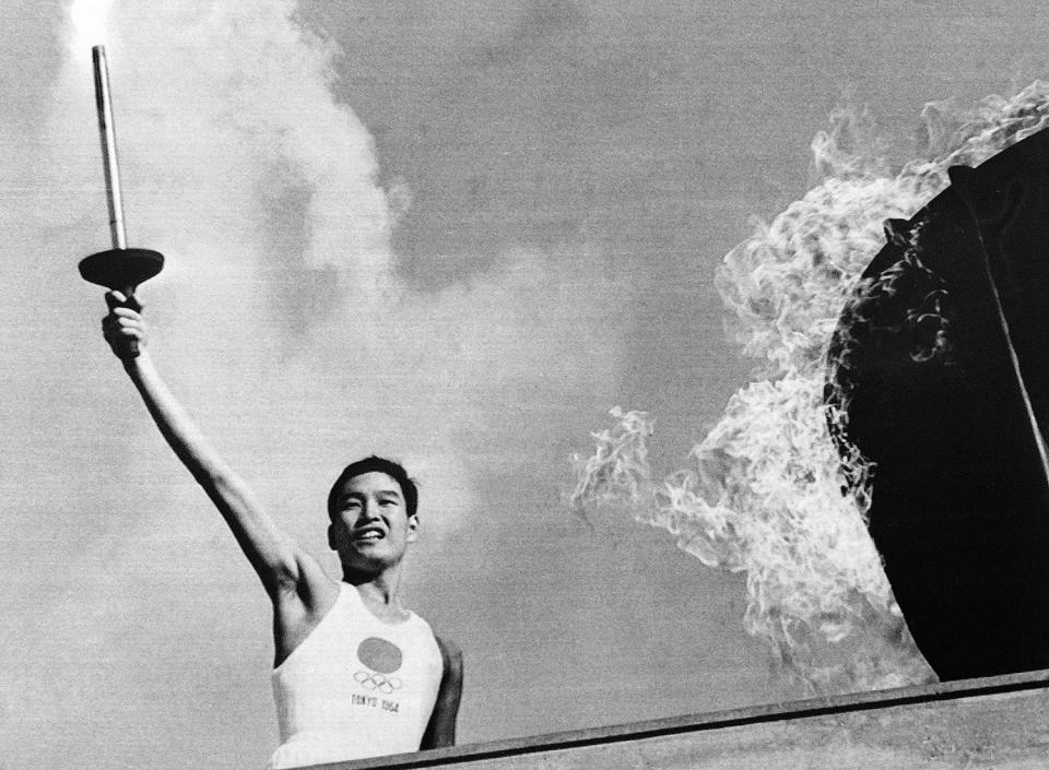 <p>Japanese Olympic torch runner Yoshinori Sakai lights the Olympic torch during the opening ceremony of the 1964 Tokyo Olympic Games. </p>