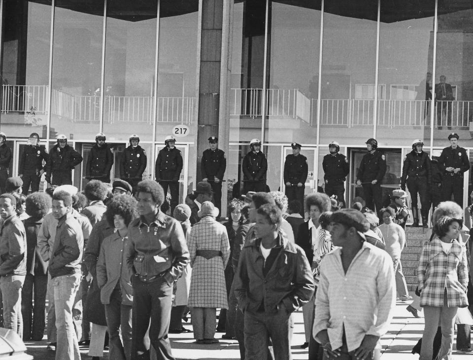 Akron police line up outside the Justice Center while protesters stands outside Oct. 17, 1972, in downtown Akron.