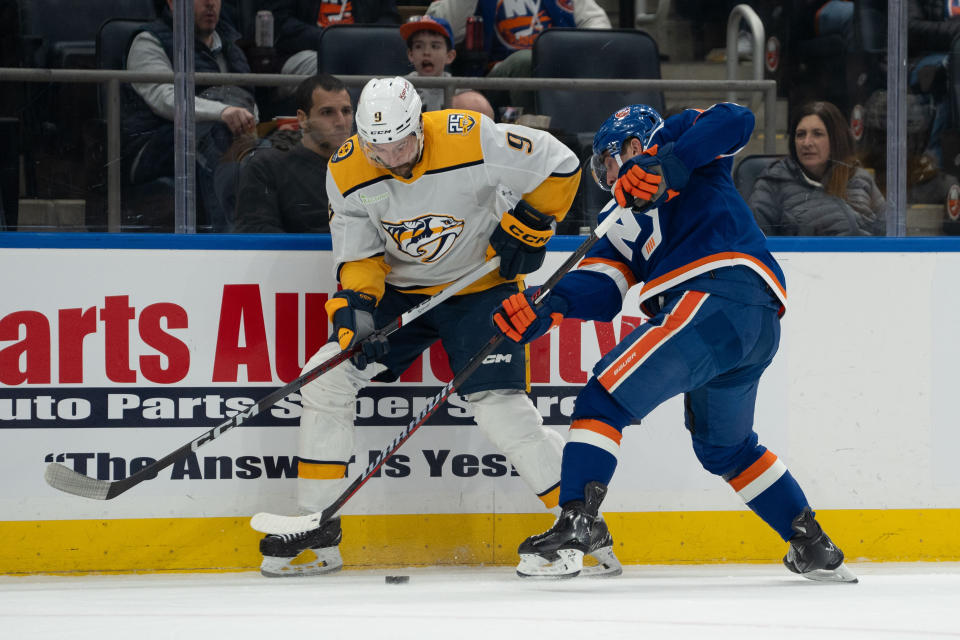 New York Islanders right wing Cal Clutterbuck, right, and Nashville Predators left wing Filip Forsberg (9) battle for the puck during the second period of an NHL hockey game in Elmont, N.Y., Saturday, April 6, 2024. (AP Photo/Peter K. Afriyie)