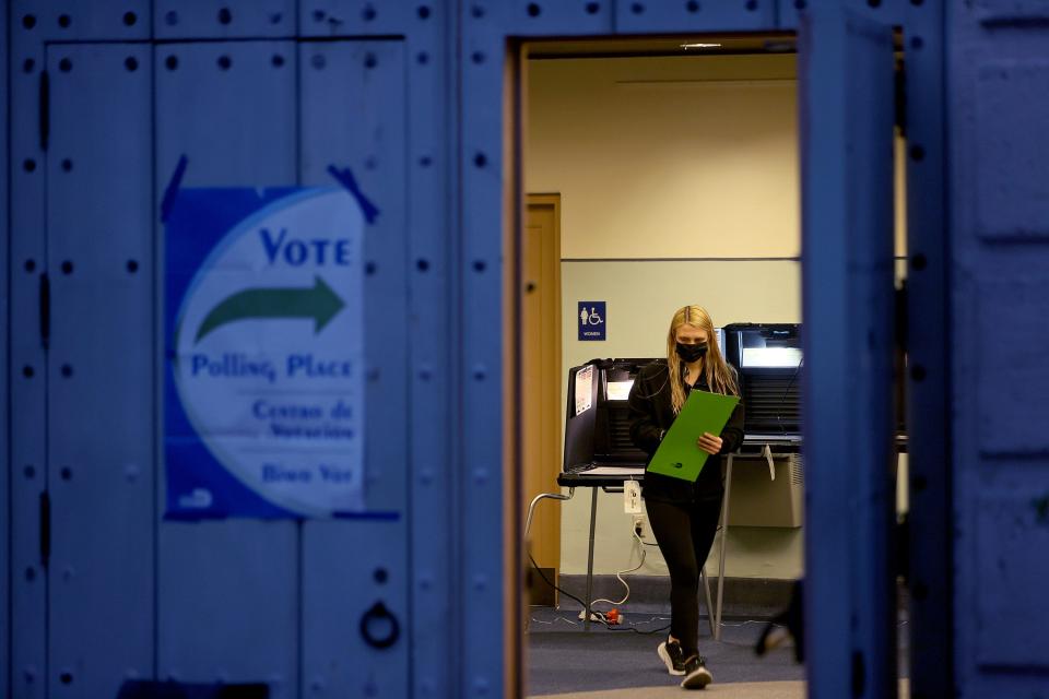 A voter carries an election ballot to the voting machine at a polling station on November 02, 2021 in Miami, Florida. Voters are casting their ballots on Election Day for their candidate of choice.