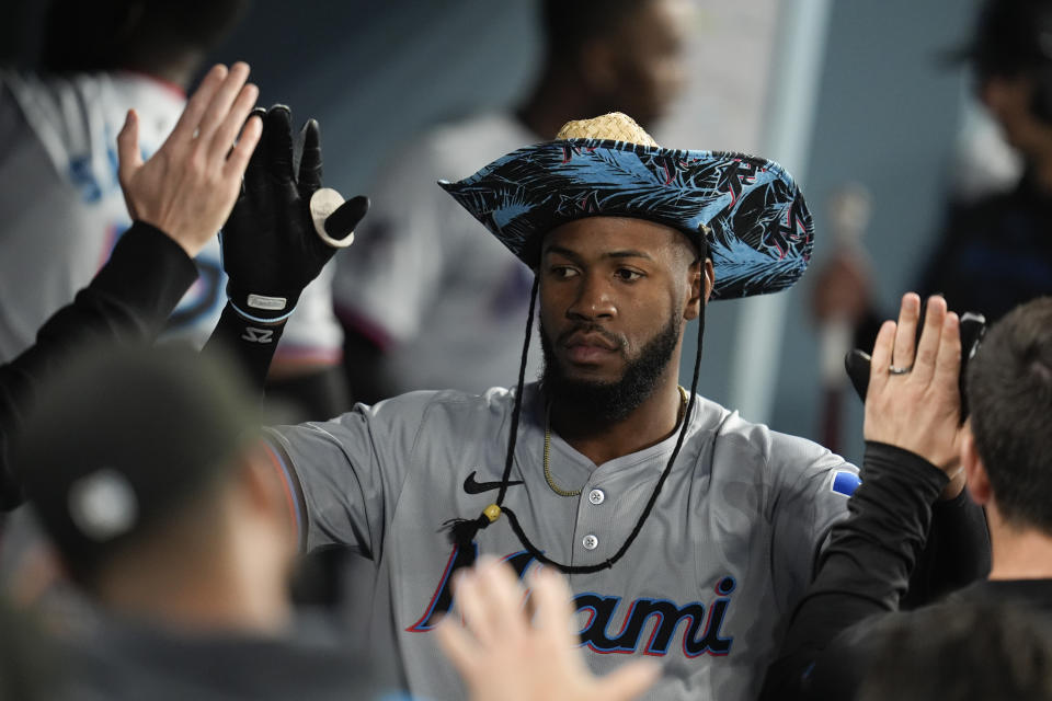 Miami Marlins' Bryan De La Cruz celebrates with teammates in the dugout after his solo home run against the Los Angeles Dodgers during the sixth inning of a baseball game Tuesday, May 7, 2024, in Los Angeles. (AP Photo/Marcio Jose Sanchez)