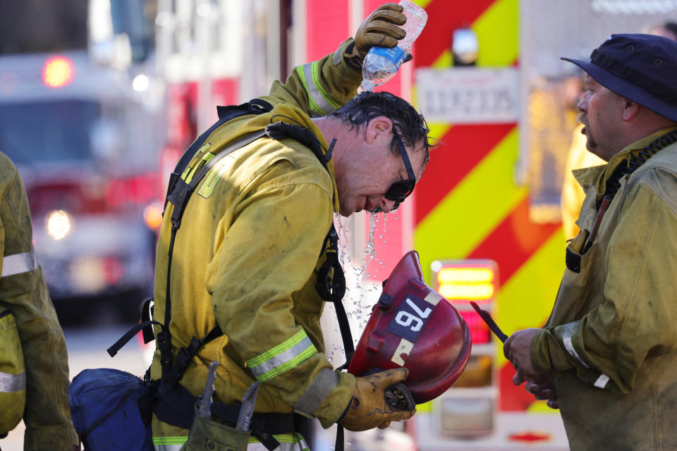 A San Bernardino County firefighter pours water over his head as the Oak Fire burns near Fontana, Calif. (David Swanson / AFP via Getty Images file )