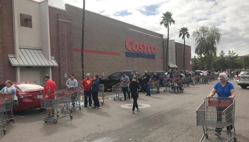 People wait in line to enter Costco to shop in Mesa.