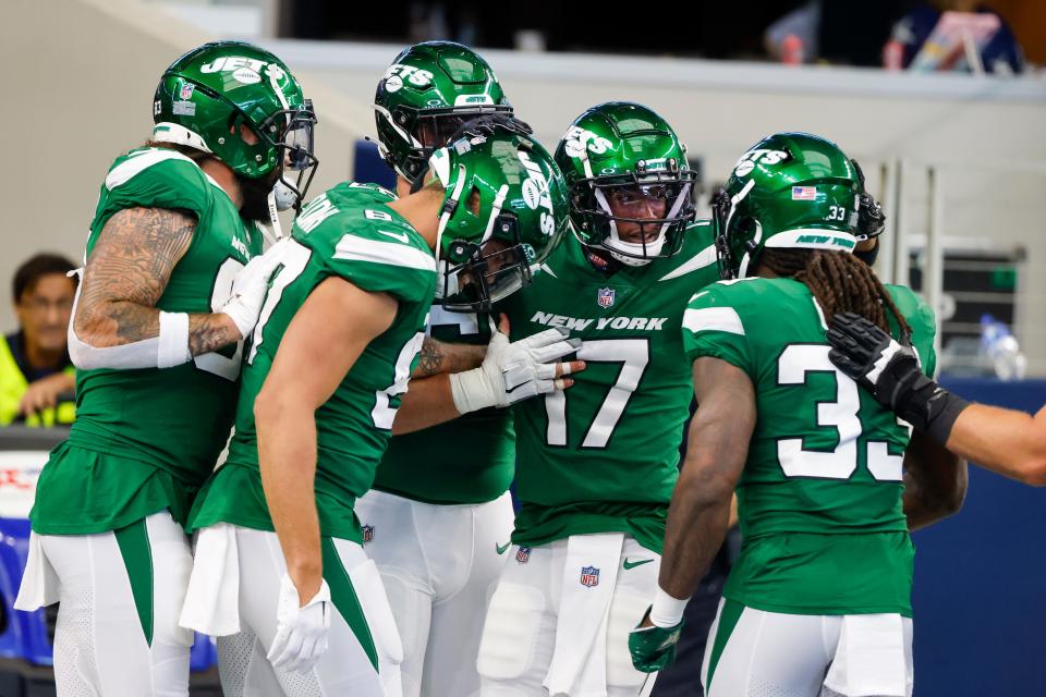 New York Jets wideout Garrett Wilson, center, celebrates with teammates after scoring on a 68-yard touchdown catch in Sunday's 30-10 loss to the Dallas Cowboys at AT&T Stadium in Arlington. The former Lake Travis star  has already established himself as one of the top young receivers in the NFL.