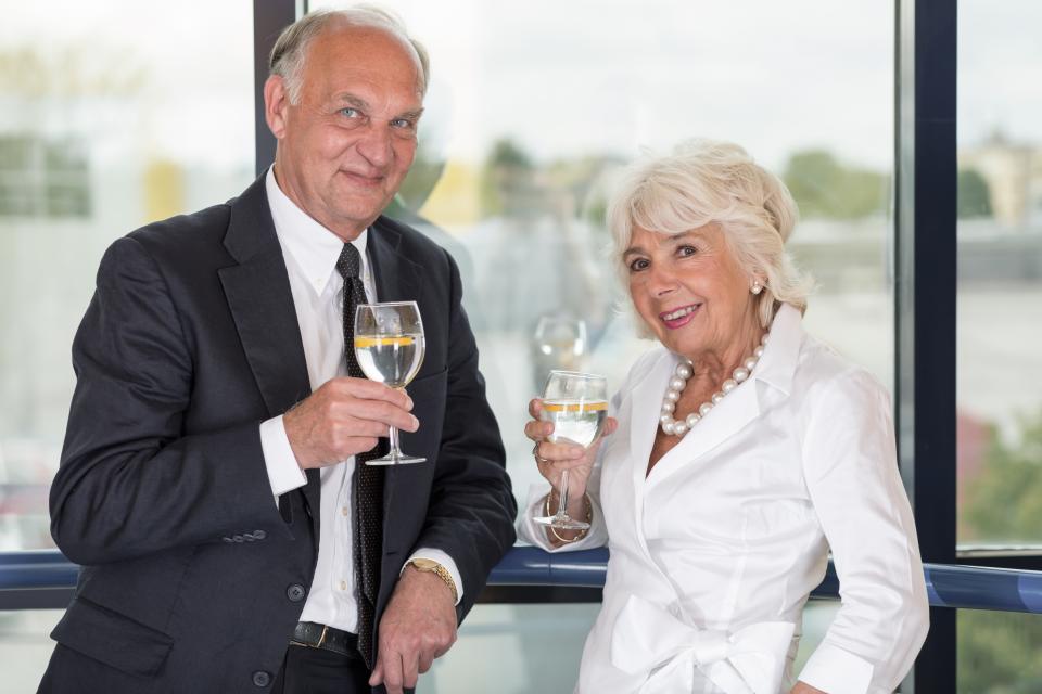 Well-dressed senior couple drinking wine