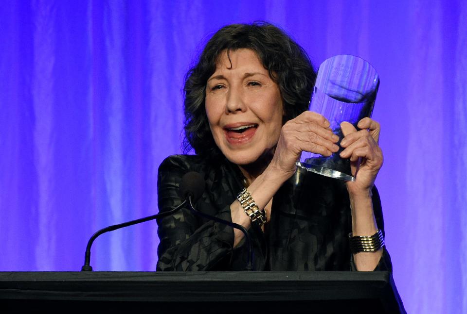 Actress Lily Tomlin, whose credits include "Rowan & Martin's Laugh-In," '9 to 5' and 'Grace and Frankie,' shows off the well-deserved award she received at the Paley Honors TV comedy tribute on Thursday.