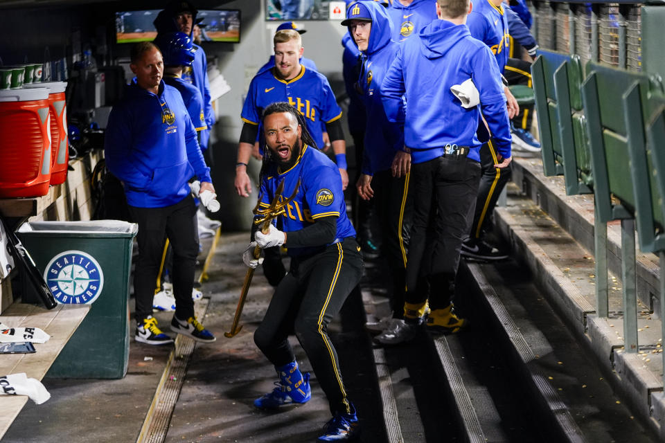 Seattle Mariners' J.P. Crawford holds a trident in the dugout after hitting a solo home run against the Boston Red Sox during the sixth inning of a baseball game Friday, March 29, 2024, in Seattle. (AP Photo/Lindsey Wasson)