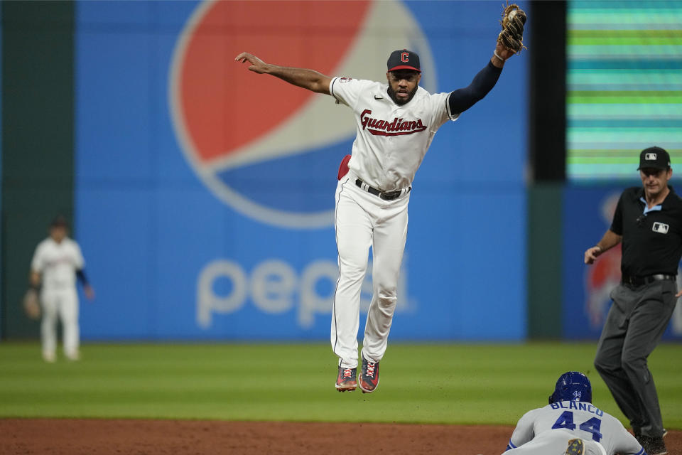 Kansas City Royals' Dairon Blanco (44) steals second base as Cleveland Guardians shortstop Amed Rosario,top, jumps for a throw in the ninth inning of a baseball game Monday, July 24, 2023, in Cleveland. (AP Photo/Sue Ogrocki)