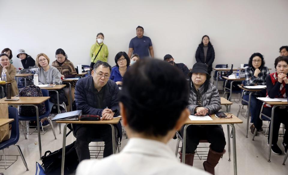 Students listen intently during a lecture by a professor.