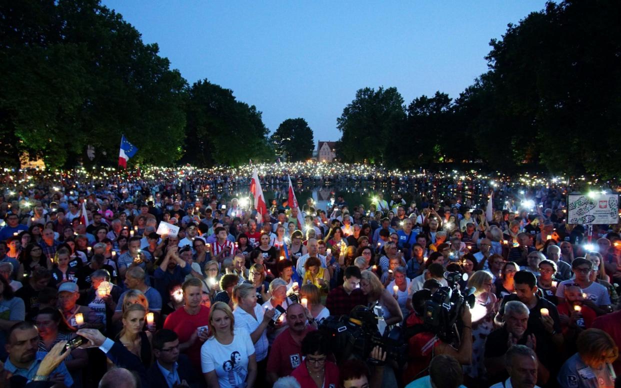 People attend a protest against supreme court legislation in Poznan - REUTERS