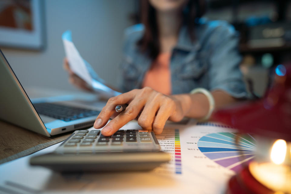 A woman using a calculator at her desk