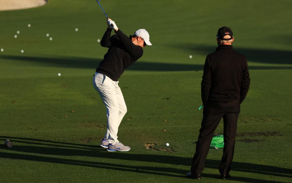 Rory McIlroy of Northern Ireland works with coach Pete Cowen on the range during a practice round prior to the Masters at Augusta National  - Getty Images