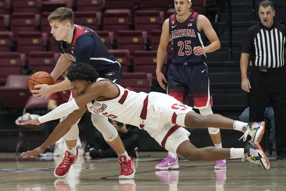 Stanford forward Harrison Ingram, front, dives for the ball next to Arizona forward Azuolas Tubelis during the first half of an NCAA college basketball game in Stanford, Calif., Thursday, Jan. 20, 2022. (AP Photo/Jeff Chiu)