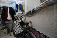 An Iranian woman weaves a carpet at a workshop in the city of Kashan, about 152 miles (245 km) south of the capital Tehran, Iran, Tuesday, April 30, 2024. (AP Photo/Vahid Salemi)