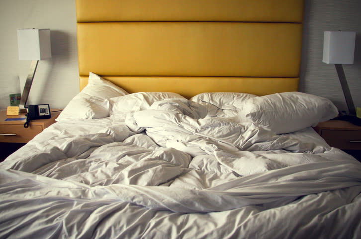 Unmade bed with rumpled white sheets and pillows, suggesting recent use or sleep