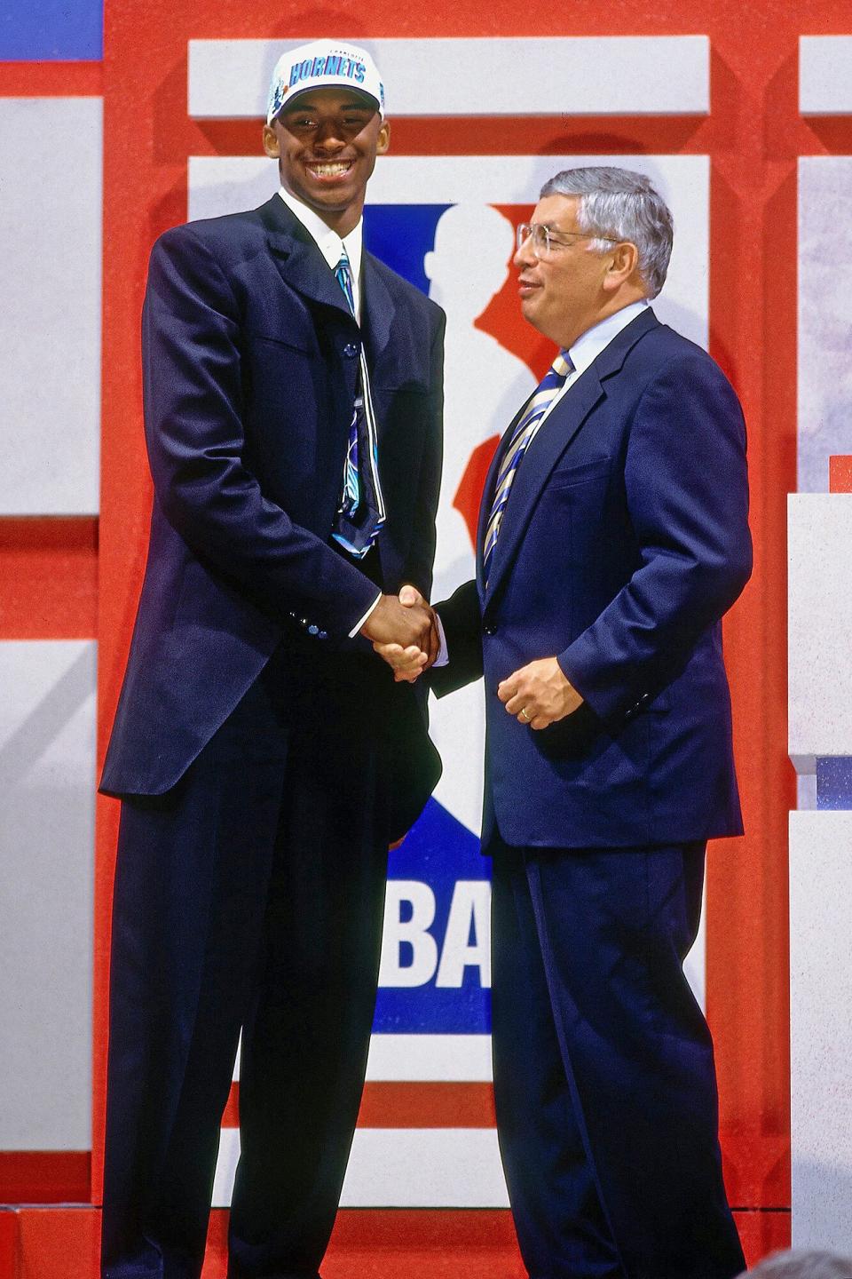 Bryant shakes hands with then-NBA Commissioner David Stern (<a href="https://people.com/sports/former-nba-commissioner-david-stern-dead-at-77/" rel="nofollow noopener" target="_blank" data-ylk="slk:who died on Jan. 1, 2020;elm:context_link;itc:0;sec:content-canvas" class="link ">who died on Jan. 1, 2020</a>) after being selected in the first round of the 1996 NBA Draft on June 26, 1996, at Madison Square Garden in N.Y.C.