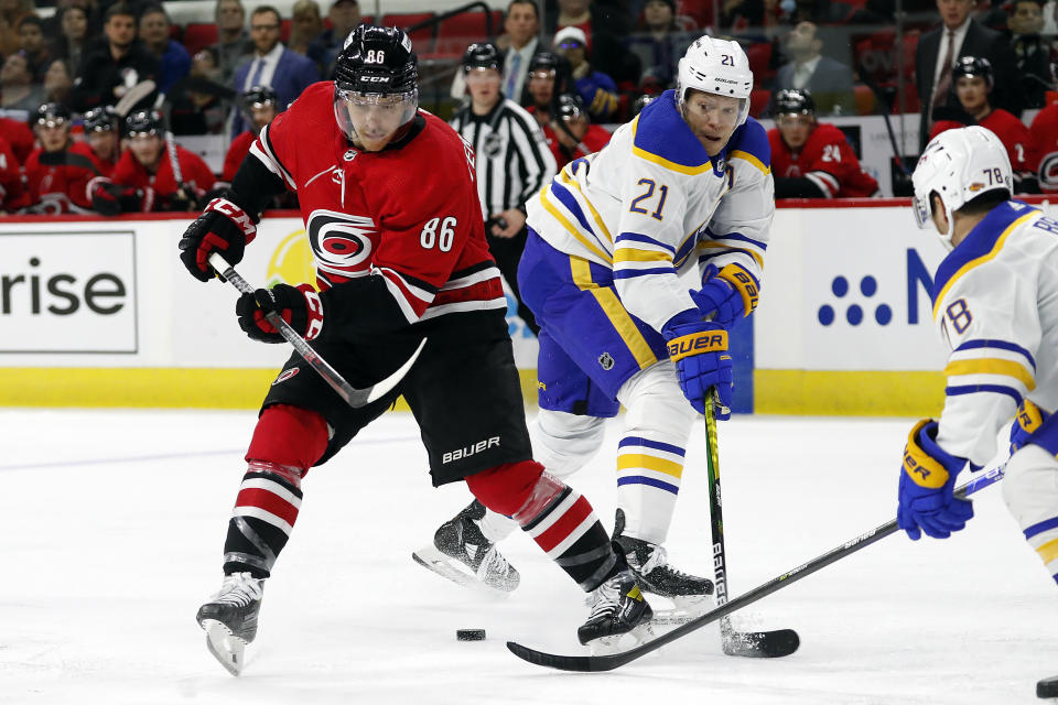 Buffalo Sabres' Jacob Bryson (78) tips the puck away from Carolina Hurricanes' Teuvo Teravainen (86) with Sabres' Kyle Okposo (21) defending during the second period of an NHL hockey game in Raleigh, N.C., Thursday, April 7, 2022. (AP Photo/Karl B DeBlaker)